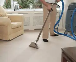 Carpet cleaning professional removing dirt and stains with a hot-water extraction tool in a home, Baton Rouge, LA.